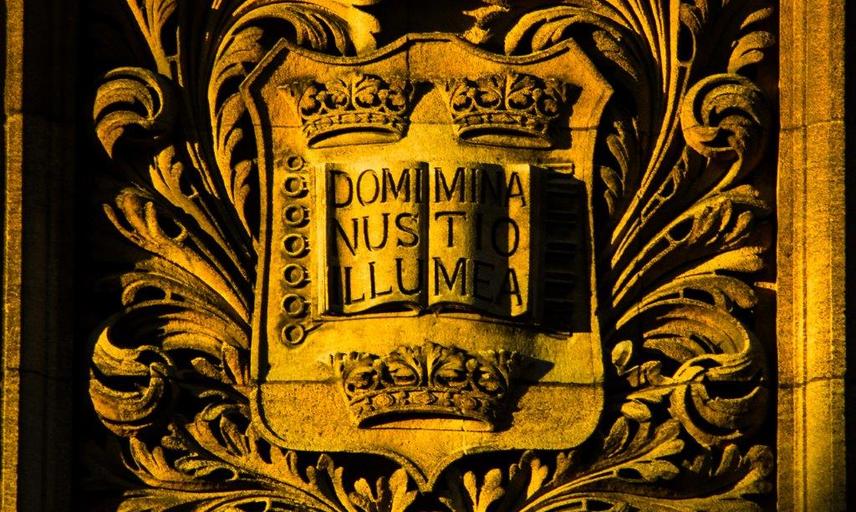 Sun drenched University shield with motto